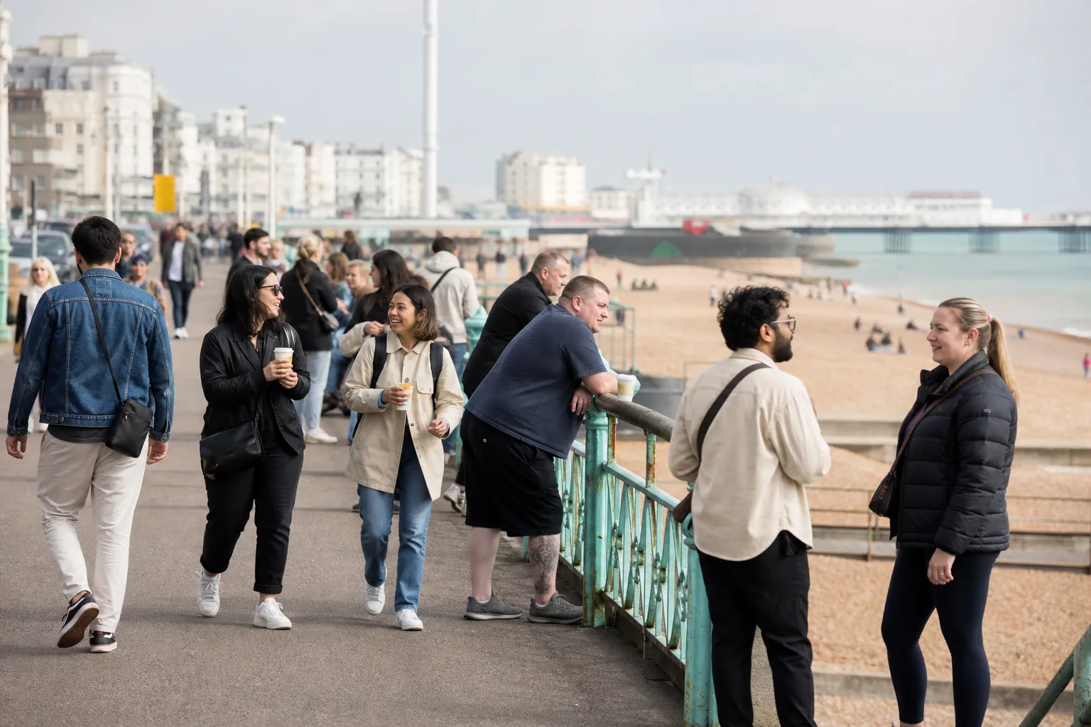 Adults chatting together at an outdoor social gathering near Brighton seafront